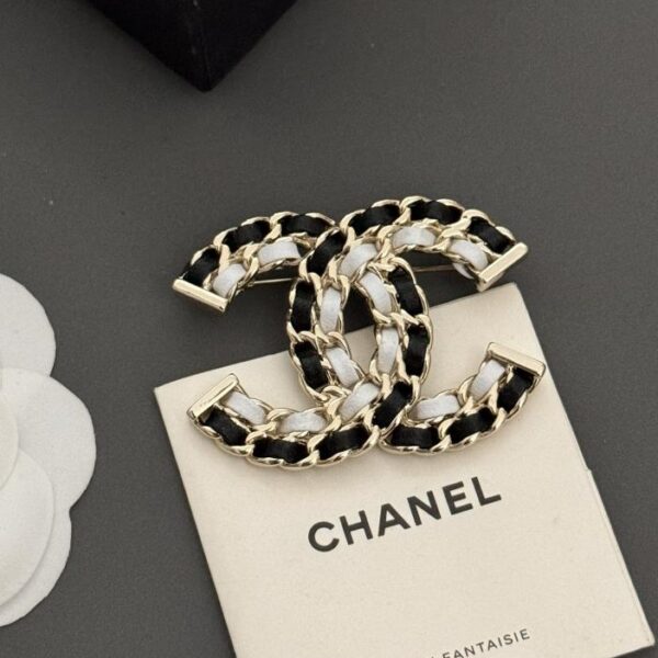 Broche Chanel neuve en cuir noir et blanc (F22F)